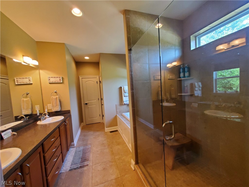8261 Rodgers Road Lodi, OH 44254 - Photo 21 of 35 Master bath with double sinks, full
mirror, walk-in ceramic tile shower with glass door, garden tub, linen closet & ceramic tile flooring.
