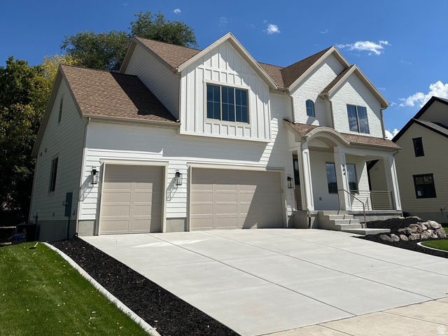 504 North 650 E Street Springville, UT 84663 - Photo 3 of 36 White siding exterior with a brown shingle roof, featuring a two-car garage, covered entry, and a concrete driveway
