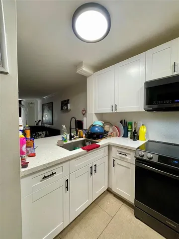 a kitchen with cabinets stainless steel appliances a sink and a microwave