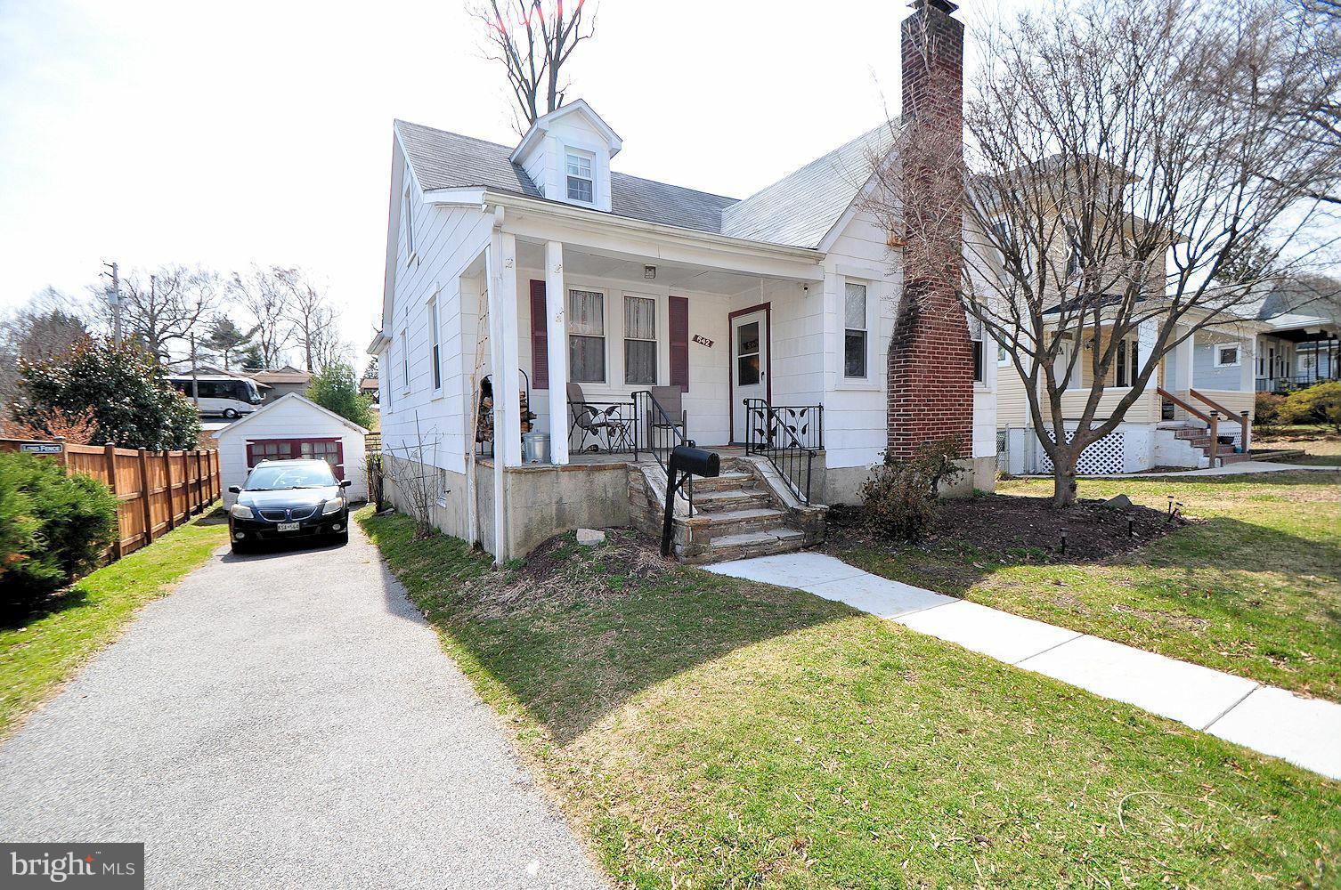 642 Coleraine Road Baltimore, MD 21229 - Photo 2 of 26 a view of a brick house with a yard and table and chairs under an umbrella