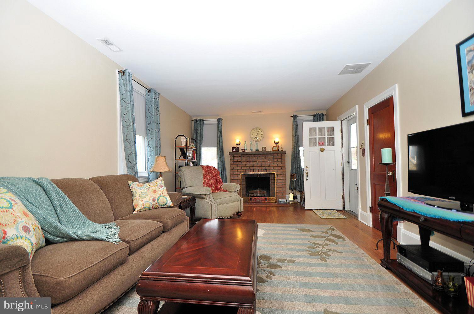 642 Coleraine Road Baltimore, MD 21229 - Photo 8 of 26 a living room with furniture a fireplace and a flat screen tv