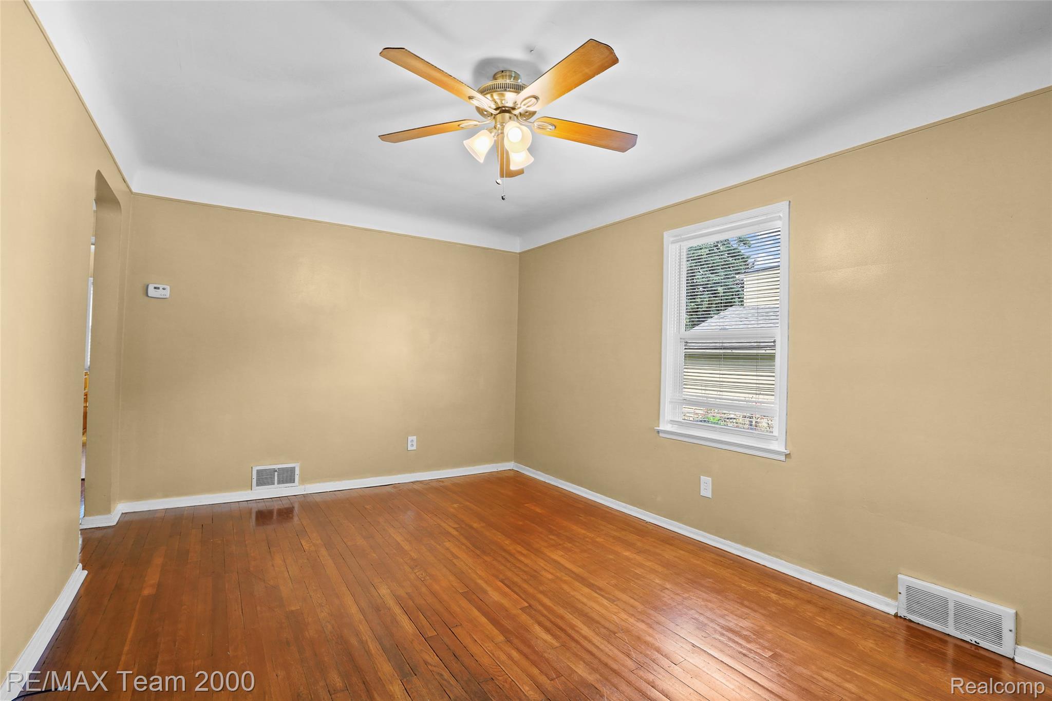 3130 Chestnut Street Dearborn, MI 48124 - Photo 13 of 30 Hardwood flooring spans this room, featuring a white trim baseboard and crown molding