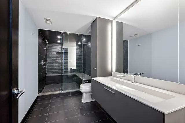 a bathroom with a double vanity sink mirror and shower
