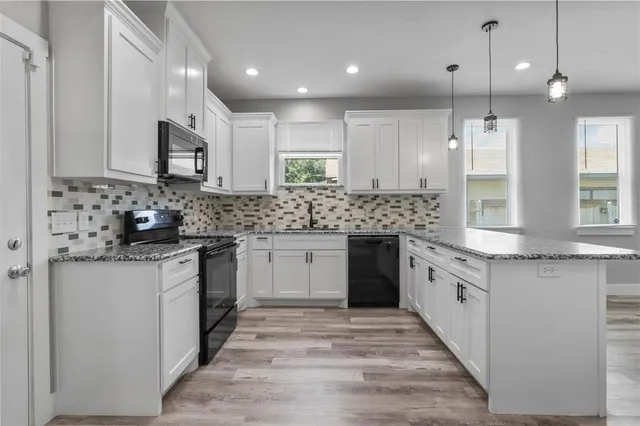 a kitchen with stainless steel appliances granite countertop a sink stove and cabinets
