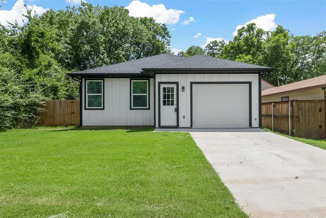 a front view of a house with a garden and yard
