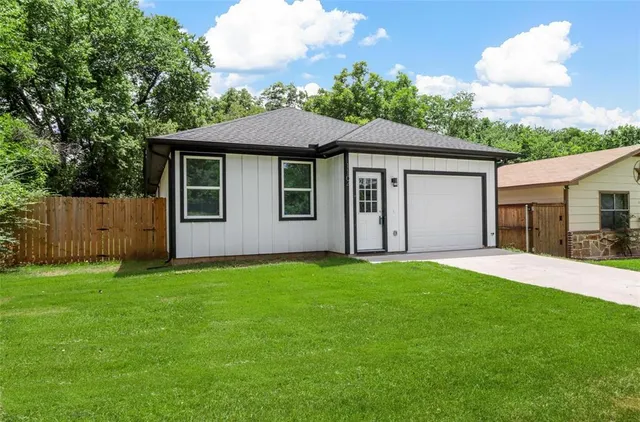 a front view of a house with yard and green space