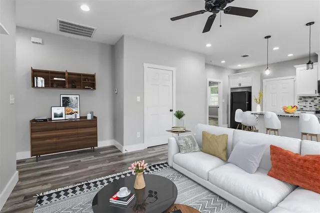 a living room with furniture and a wooden floor