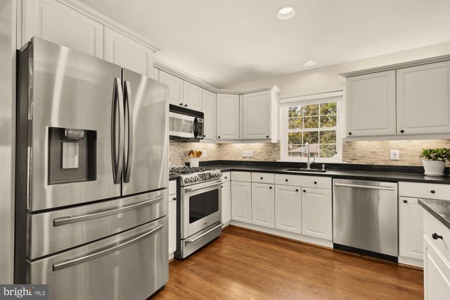 a kitchen with granite countertop white cabinets and white appliances