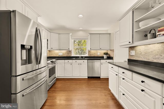 a kitchen with granite countertop white cabinets and white appliances
