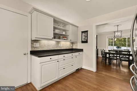 a kitchen with cabinets stainless steel appliances and wooden floor