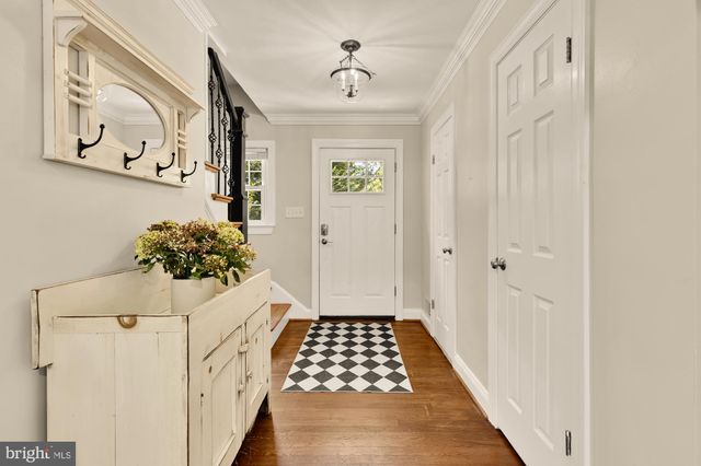 a view of a hallway with wooden floor and furniture