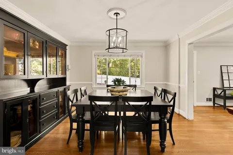 a dining room with furniture window and wooden floor
