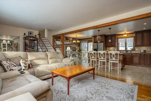 a living room with furniture a kitchen view and a large window