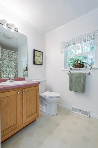 a bathroom with a toilet a sink and mirror