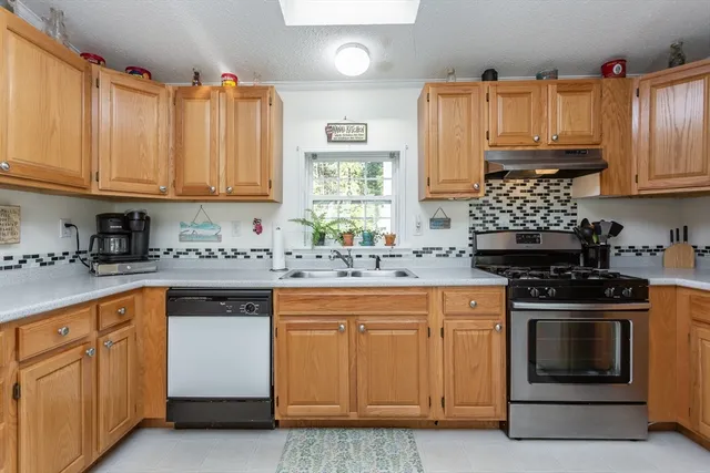 a kitchen with cabinets appliances a sink and a window