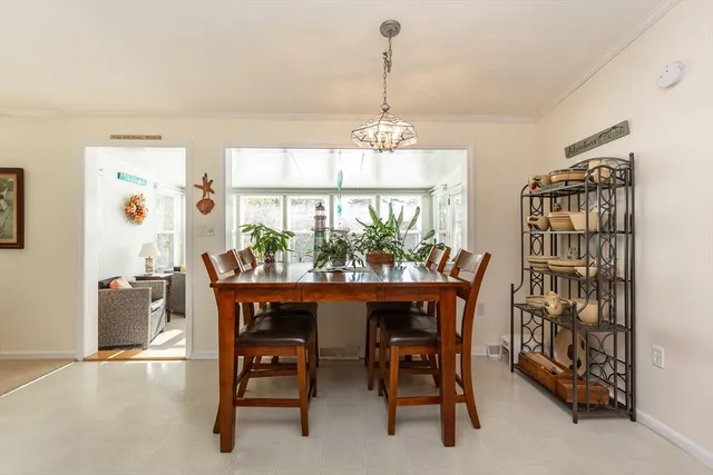 a dining room with furniture a chandelier and window