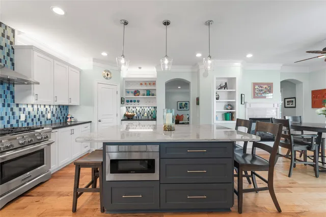 a kitchen with a table chairs stove and cabinets