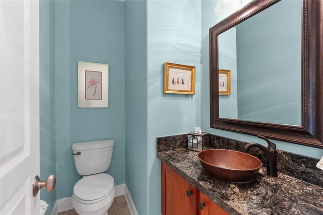 a bathroom with a granite countertop toilet sink and mirror
