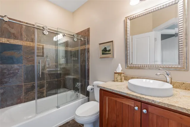 a bathroom with a granite countertop sink toilet and shower