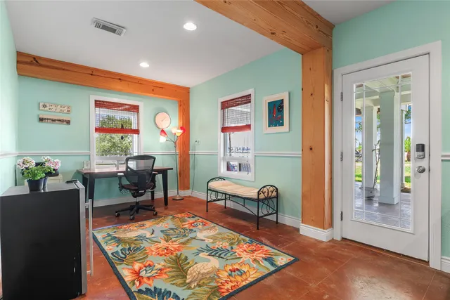 a view of a hallway with workspace and a window