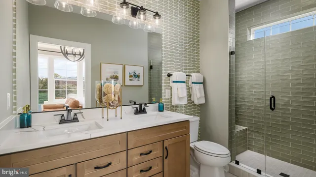 a bathroom with a double vanity sink toilet and shower
