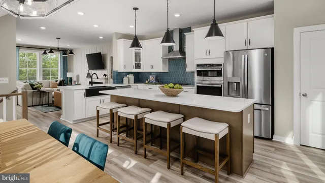 a kitchen with granite countertop a table chairs microwave and refrigerator