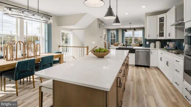 a large kitchen with kitchen island a large counter space a sink a dining table and chairs