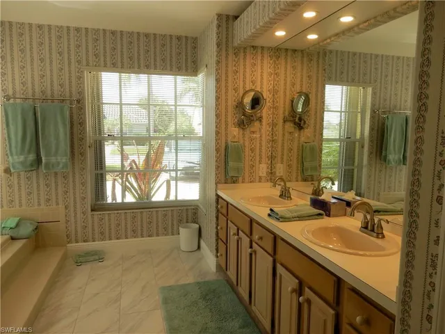 a bathroom with a tub sink and mirror