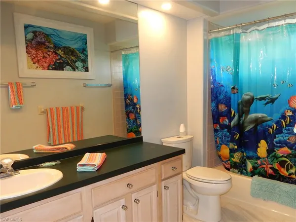 a bathroom with a sink a toilet and a shower curtain
