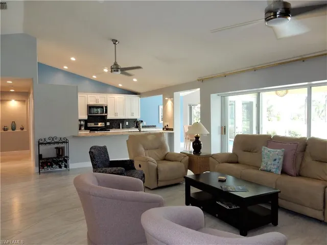 a living room with furniture kitchen and a large window