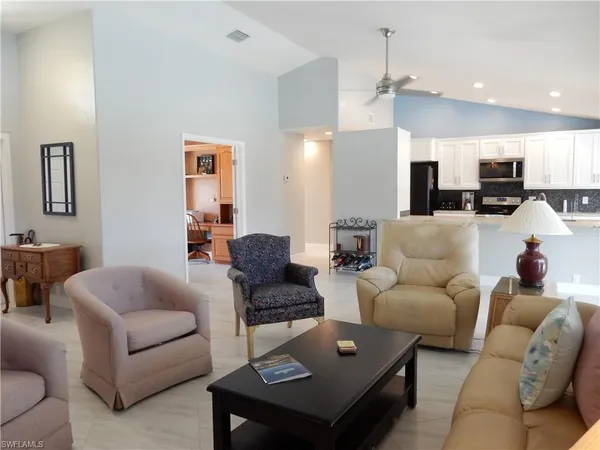 a living room with furniture kitchen view and a table