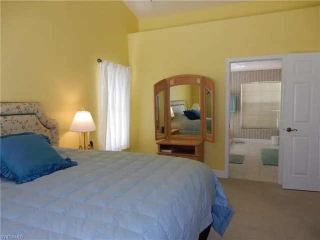 a bedroom with a bed and a lamp on table