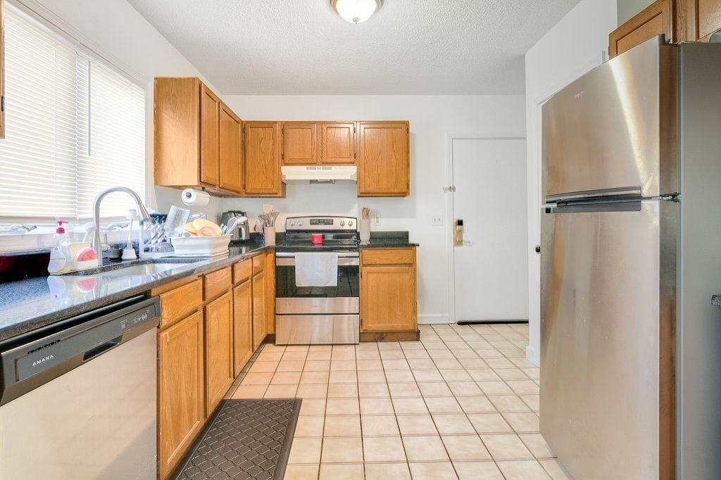 890-892 St James Avenue Springfield, MA 01104 - Photo 13 of 30 a kitchen with stainless steel appliances a refrigerator sink and cabinets