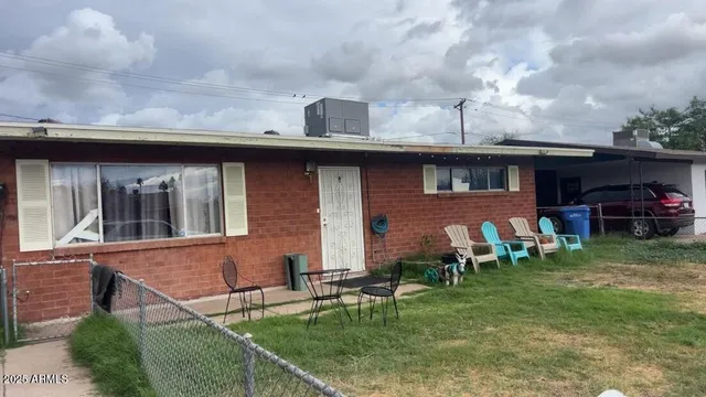 a backyard of a house with table and chairs