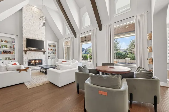 a living room with fireplace furniture and a large window
