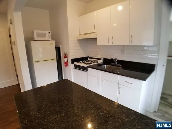 a kitchen with a sink a refrigerator and cabinets