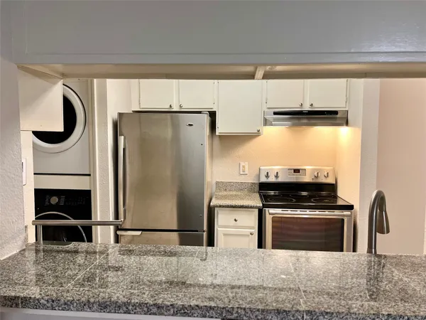 a kitchen with stainless steel appliances granite countertop a stove a refrigerator and a sink