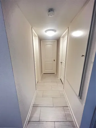 a view of an empty room with a chandelier fan