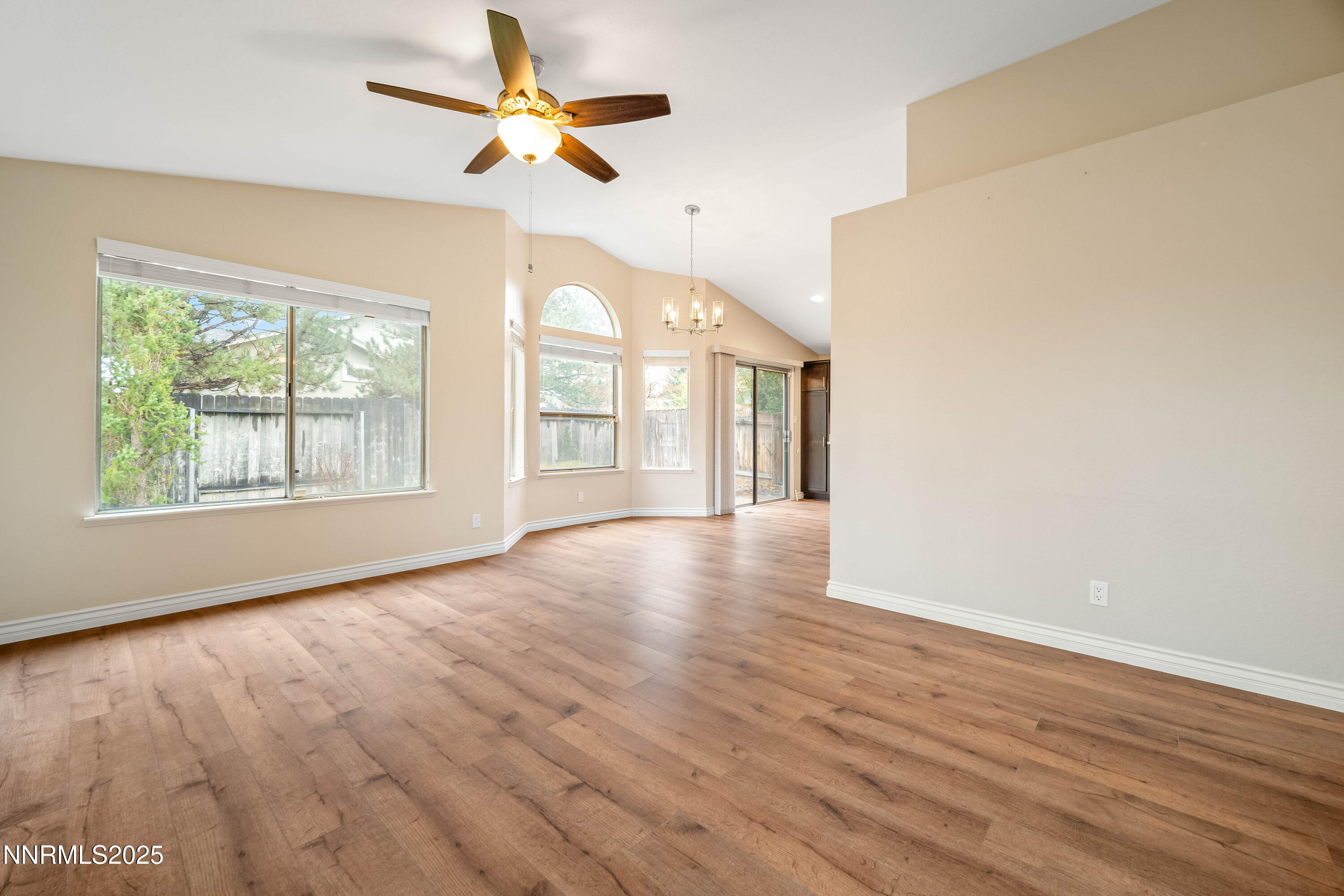 1146 Ambassador Drive Reno, NV 89523 - Photo 3 of 23 an empty room with wooden floor chandelier fan and windows