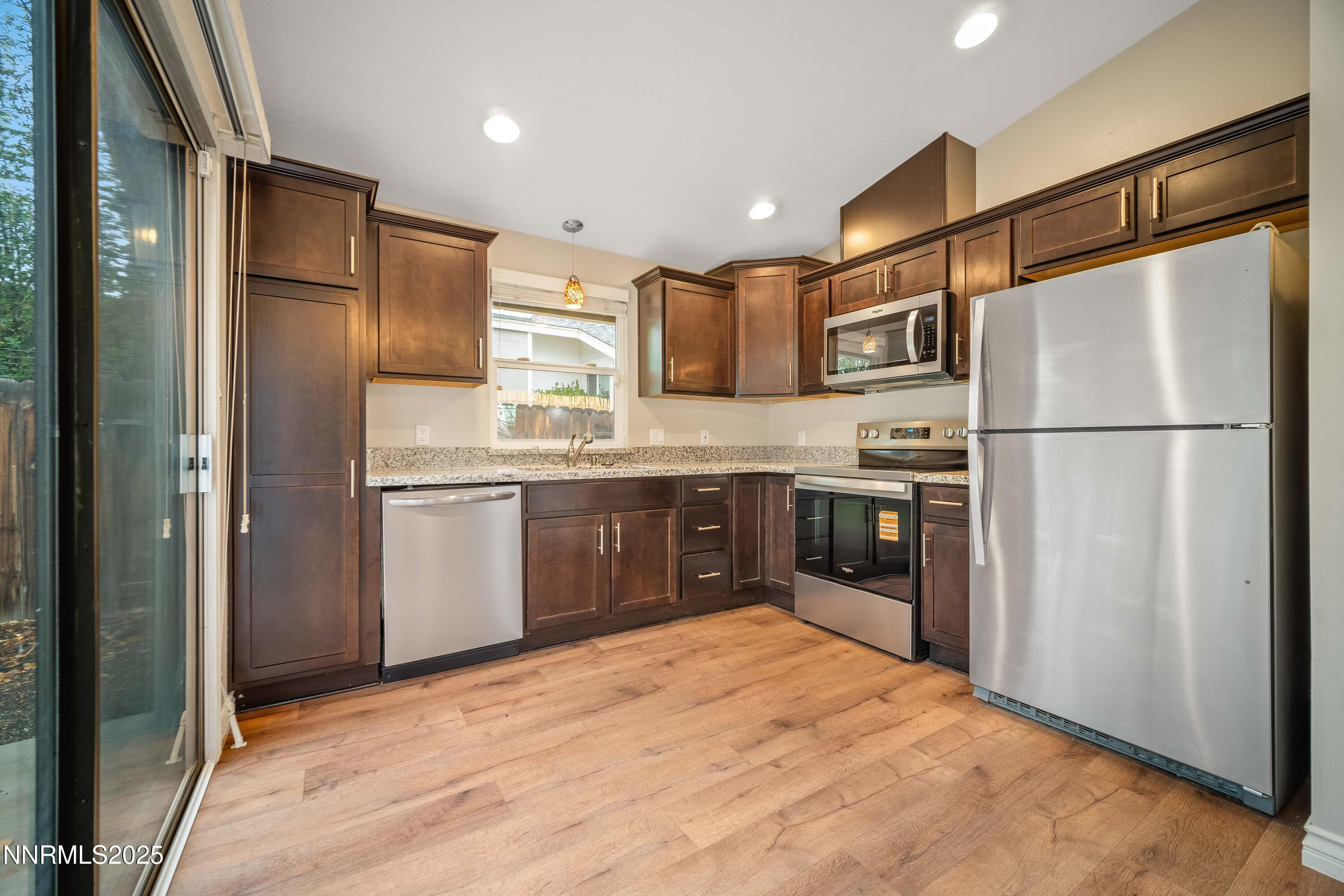 1146 Ambassador Drive Reno, NV 89523 - Photo 5 of 23 a kitchen with stainless steel appliances granite countertop a refrigerator a stove and a sink