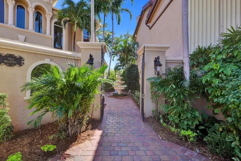 a view of a pathway with house with flower plants and wooden fence