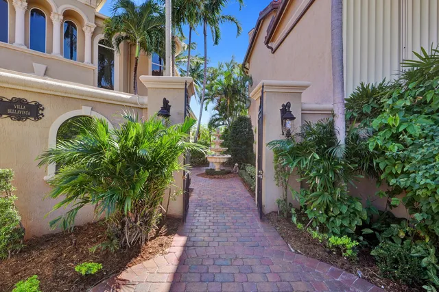 a view of a pathway with house with flower plants and wooden fence