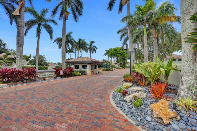 a front view of a house with a yard and palm trees
