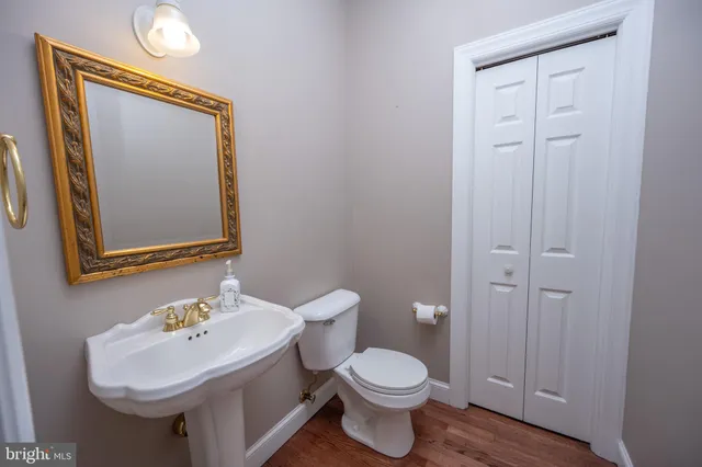 a bathroom with a toilet a sink and cabinets