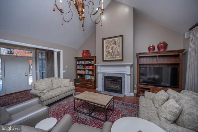 a kitchen with stainless steel appliances granite countertop a refrigerator a stove a sink a dining table and chairs with wooden floor