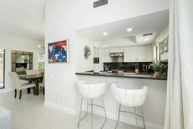 a kitchen with stainless steel appliances kitchen island granite countertop a refrigerator and cabinets