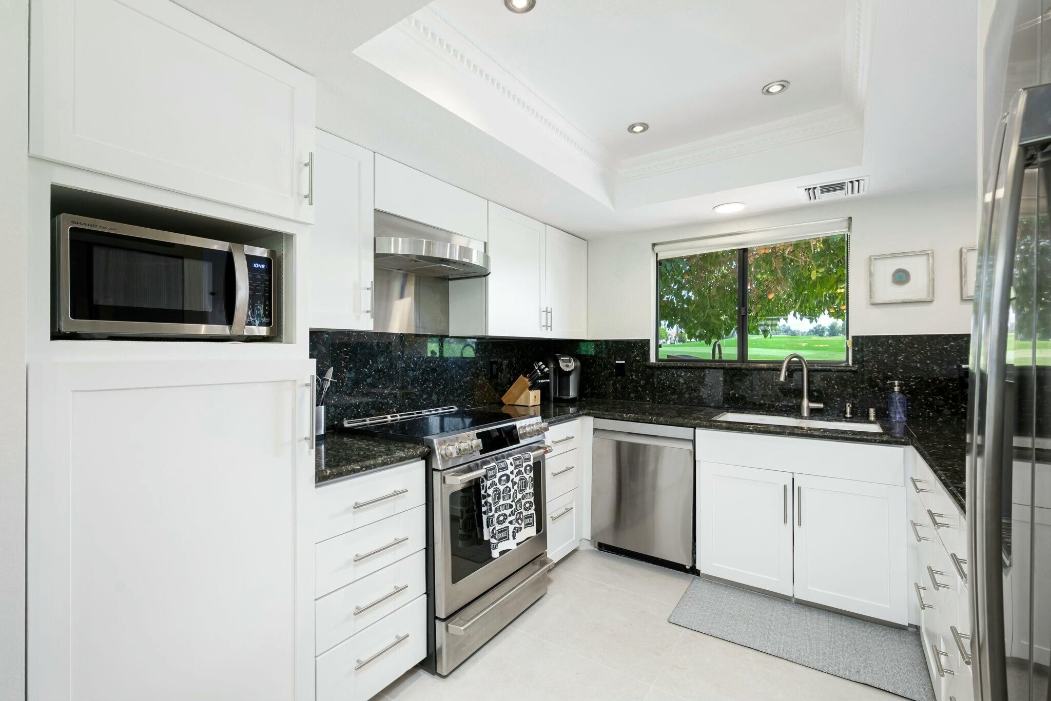 38 Mission Court Rancho Mirage, CA 92270 - Photo 35 of 61 a kitchen with granite countertop white cabinets and white appliances