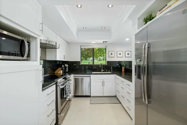 a view of house with a backyard and patio