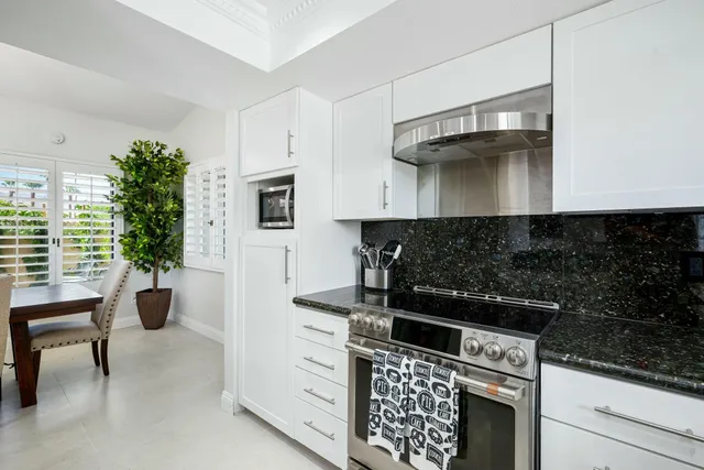 a view of a patio with couches table and chairs and potted plants