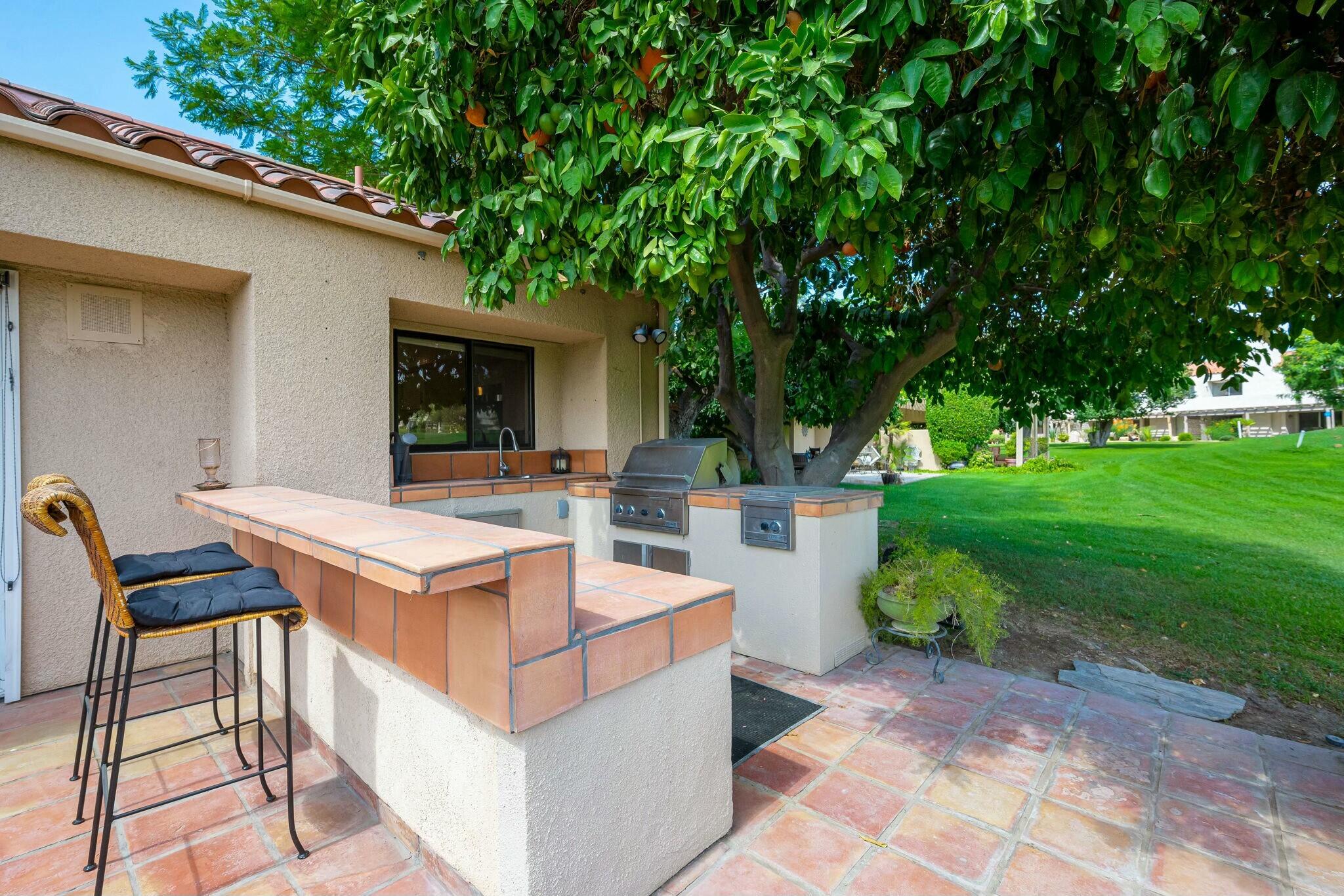 38 Mission Court Rancho Mirage, CA 92270 - Photo 44 of 61 a view of a patio with table and chairs and garden